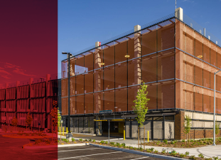 Photo of Puyallup parking garage, a 5 story building with brightly colored orange paneling.